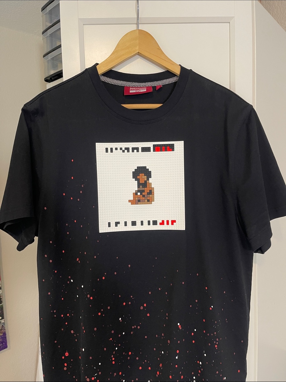 Mostly Heard Rarely Seen Black Tee with Pixel Graphic and Red/White Splatter